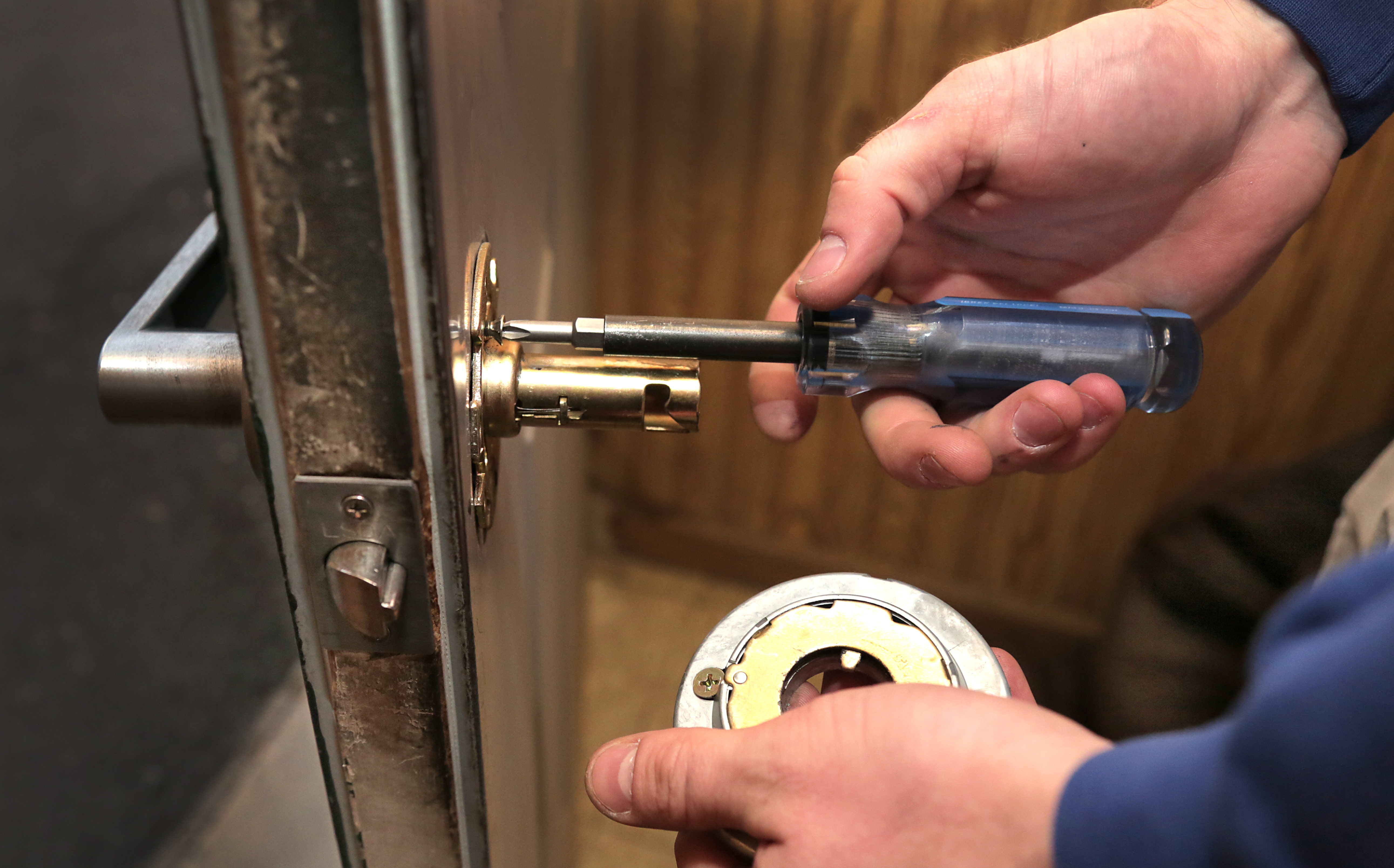 locksmith using tool to fix lock on door